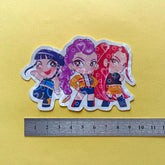 The aforementioned image but a ruler is showing the scale and size of the sticker.