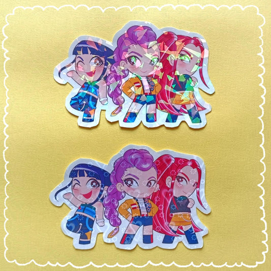 Photo of 2 stickers featuring the main women characters in chibi style from the movie about Demon Hunters and they're also in a KPop band. Each sticker has a different holographic style pattern.