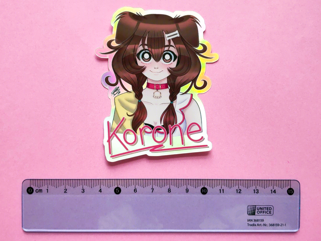 Photo of a holographic sticker of hololive vtuber Inugami Korone illustrated from the bust up. There's a blue ruler underneath it to show a size comparison.